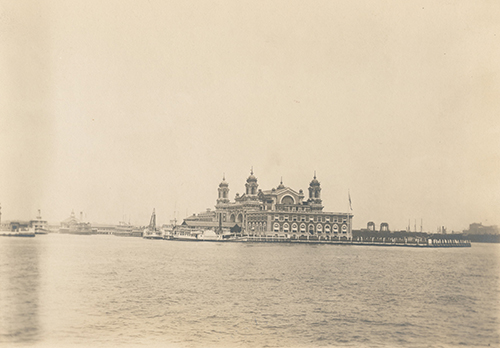 nypl.digitalcollections.A view of Ellis Island taken from the harbor. At the center is the Immigration Station; one of the boats in the pier is the John E. Moore.(500)